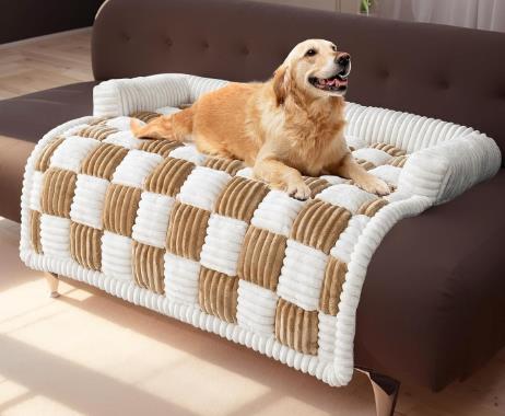 Golden retriever on plush checkered dog mat in white and brown on a sofa.