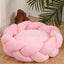 Handmade pink knit pet bed for cats and dogs, cozy braided design, perfect for pet comfort and relaxation.