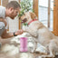 Man using Automatic Electric Dog Paw Cleaner with USB charging to clean yellow labrador's paws indoors