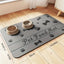 Splash-proof pet feeding mat with paw and bone designs, featuring diatom mud material and two pet bowls for cats and dogs.