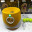 Automatic dog tennis ball launcher with yellow design, includes tennis balls, packaging, and quick start guide.