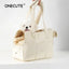 Small white dog in a Puppy Go Out Portable Dog Carrier Bag with a padded interior and breathable mesh panels for comfort.