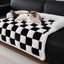 Soft plush dog mat with black and white checkered design on a sofa, perfect for pet comfort and home decor.