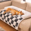 Plush dog mat in checkered design on a sofa, providing cozy comfort for a resting pet.